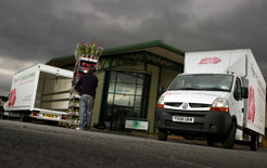 Worker unloads flowers from Renault van
