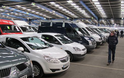 A buyer inspects a line up of used vans for offer at BCA auction