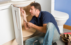 A plumber working on a sink. HMRC is targeting plumbing trades for non-payment of tax